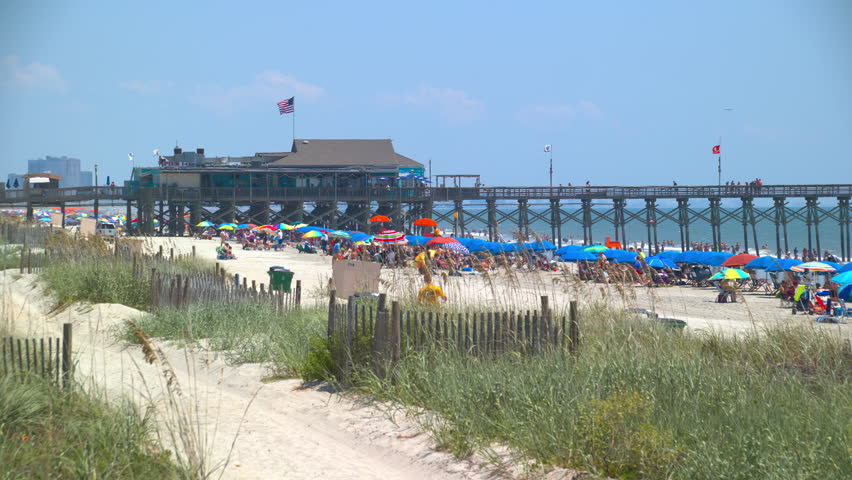 Vibrant Beach Scene at Pier 14 in Myrtle South Carolina on a Sunny Day with Umbrellas and People Enjoying the Popular East Coast Destination in Summer