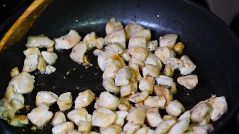 Pieces of chicken fillet fried in a pan. Chicken fillet with spices.