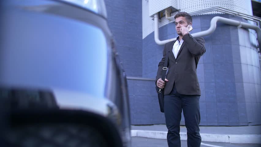 Young perspective businessman talk on mobile, stands beside with fashionable car Royalty-Free Stock Footage #31760152
