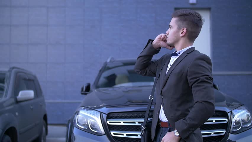 Young perspective businessman talk on mobile, stands beside with fashionable car Royalty-Free Stock Footage #31760224