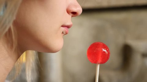 bodymification. a girl with a split tongue licks lollipop. 4k, slow-motion shooting, copying space