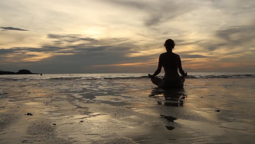 Young woman practicing yoga at sunset on the seashore (HD)