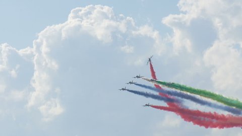 MOSCOW, RUSSIA July 21, 2017: military airplanes demonstrate aerobatics figures releasing multicolored smoke in blue sky with white clouds at air show