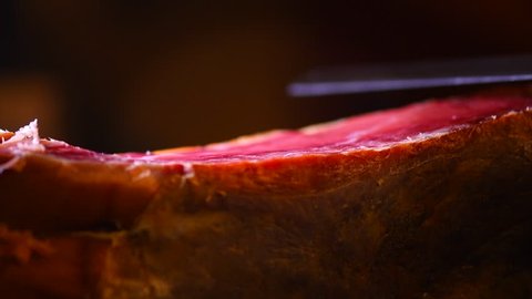 Jamon. Jamon serrano. Traditional Spanish ham on black close up. Slicing Hamon iberico. Prosciutto close up. 4K UHD video 3840x2160 