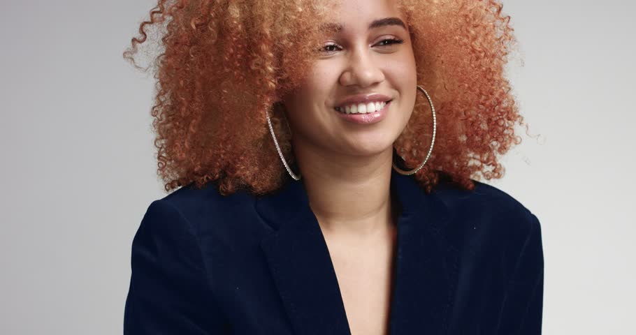 Pretty attractive young mixed race model with large afro wearing navy jacket over her naked body and shorts
