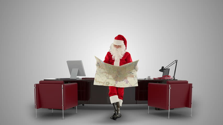 Santa Claus reading a map in his modern Christmas Office, against white