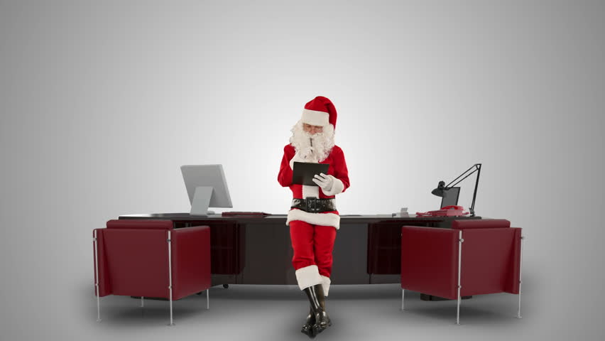 Santa Claus taking notes on a clipboard in his modern Christmas Office, against