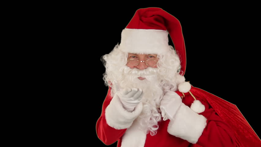 Santa Claus carrying his bag, is looking at the camera, sends a kiss and wave,
