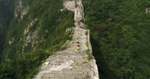 Aerial flying drone view of ultra marathon young fitness woman trail runner running on great wall