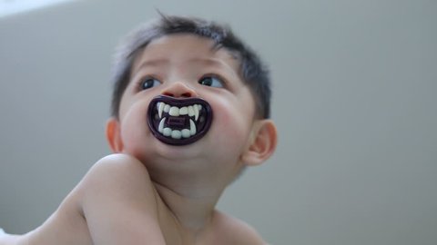 asian baby kid sucking nipple pacifier fancy vampire teeth dracula devil in halloween celebration party