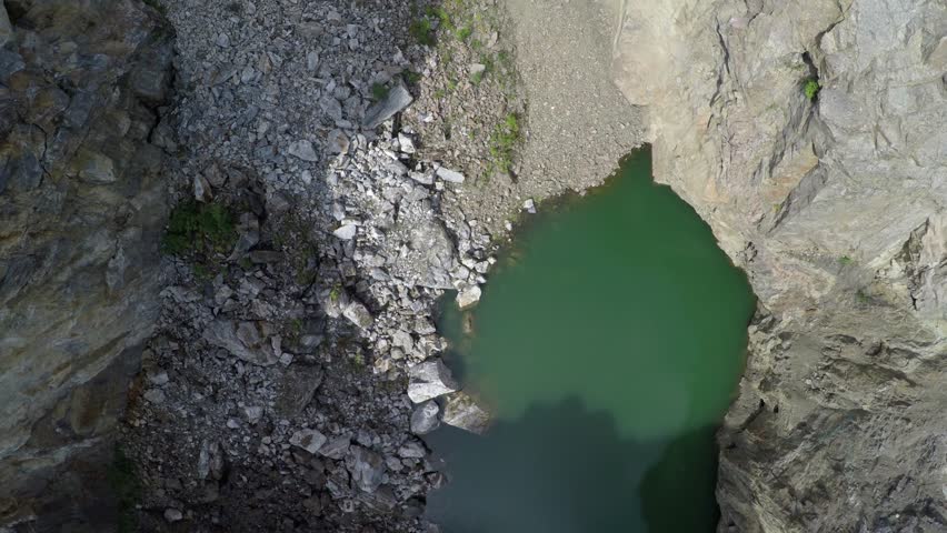 Tuimsky Proval 01. Deep technogenic collapse pit (failure) inside a mountain on the site of excavation of polymetallic ores. Static shot. Tuim, Shira district, Republic of Khakassia, Russia.