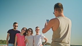 Young people posing for a photo on the beach. Medium shot. Soft Focus.