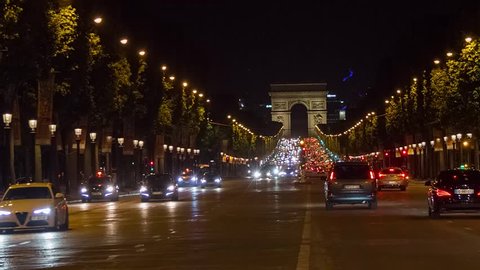 PARIS, FRANCE - JUNE 10, 2017: A trafic on Chaps Elysees at night with triumphal arch on background