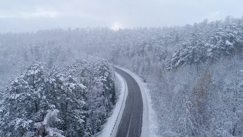 Road in the winter forest. Heavy snowfall. Aerial View.
