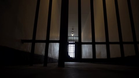 Prison Bars Open in a Dark, Depressing Looking Jail Cell.