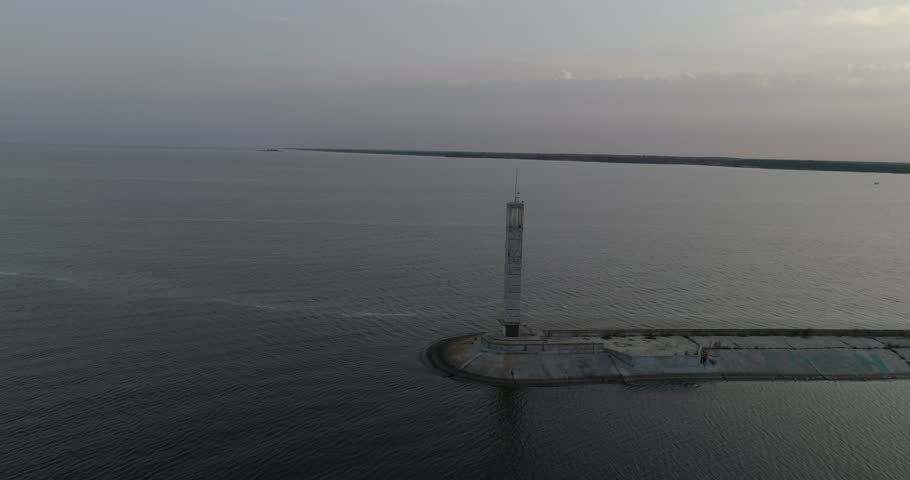 Ukraine. Kiev. Vyshgorod. Kyiv Sea. Aerial. Dnieper. Lighthouse. Sunrise. Reservoir. GAES. GES. Sunshine on the water. Nature. Dron blocks the lighthouse from the left to the right. Sky. Trees. Forest