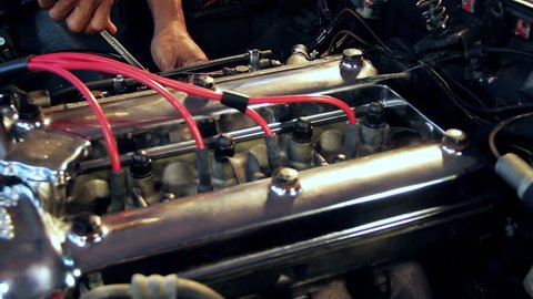 Auto mechanic repairs an engine from a classic car