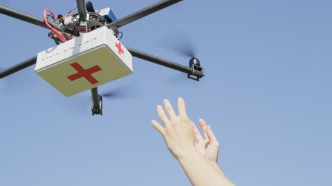CLOSE UP: UAV aerial drone delivery. Multicopter flying with first aid medicine package. Person' arms receiving first aid SOS delivery drone from sky. Medical air shipment by first responder drone