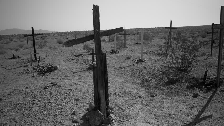 VERY OLD WESTERN CEMETERY, 4K.  Black and white, lwide lock off shot of simple wooden crosses in a desert cemetery.  Shot in 4K, 10 bit, 4:2:2.