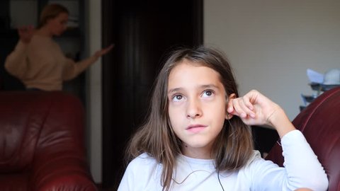 mom scolds her daughter in her room, and she ignores her and listens to music on headphones. 4k, slow motion. copy space