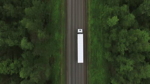 Trucks driving / traveling on the forest asphalt road aerial footage / top view / Highway truck traffic