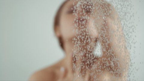 woman taking a shower in slow motion, beautiful girl washing and enjoy herself under a shower, close up of hands, chest and body details