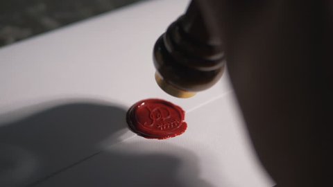 Wax sealing on invitation, using a candle