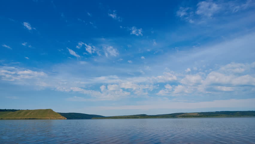 Sunny day on the sea, clouds move on the sky. Time lapse.