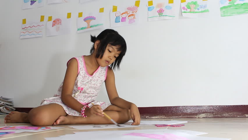 Little Asian girl painting picture