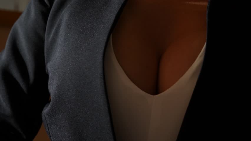 a woman with a beautiful chest puts on a black jacket. 4k, slow motion