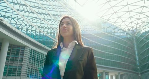 A businesswoman in a business suit, exulted by happiness after finishing the deal, in the background skyscrapers. 