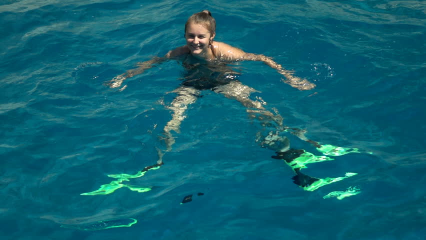 Happy, teenage girl swimming in sea with flippers, super slow motion 240fps
