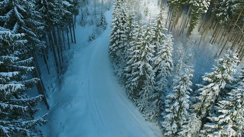 SUV rides on a mountain snow road. Top view