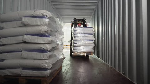 Loader driver of transport company load and unload pallets with bags