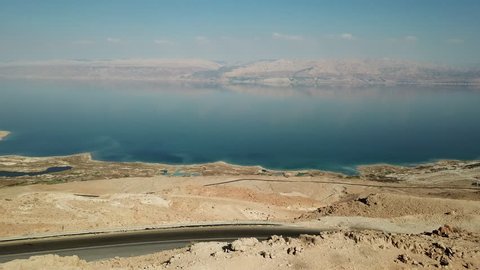 Aerial View of the Dead Sea from a cliff facing Jordan with red mountains in the background