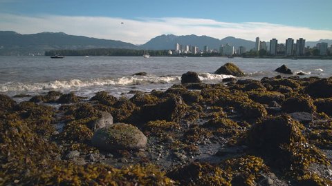 Kitsilano Low Tide Skyline, Vancouver 4K UHD. Kitsilano Beach on English Bay in the morning. In the background are the North Shore Mountains. Vancouver, British Columbia, Canada. 4K. UHD.
