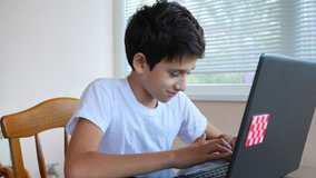 boy teenager uses laptop at home. communication in social networks, training. 4k, slow-motion shooting, copy space