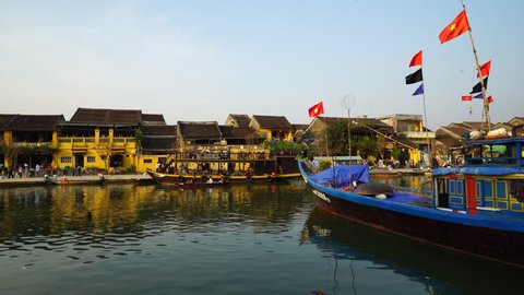 HOI AN, VIETNAM, JANUARY 2017: Traditional boats in front of ancient architecture in Hoi An, Vietnam. Hoi An is the World's Cultural heritage site, famous for mixed cultures & architecture.