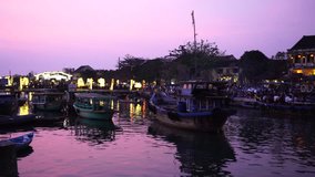 HOI AN, VIETNAM, JANUARY 2017: Traditional boats in front of ancient architecture in Hoi An, Vietnam. Hoi An is the World's Cultural heritage site, famous for mixed cultures & architecture.

