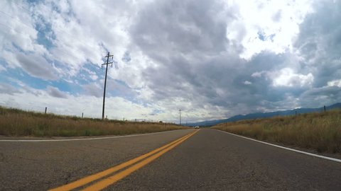 Driving in rural area of Western Colorado on cloudy day.