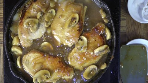 Pork chops simmering in mushroom gravy