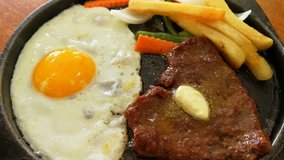 Beef Steak, Fried Egg and Vegetables on the Black Metal Plate, Foods Background 4K Video Footage Clip
