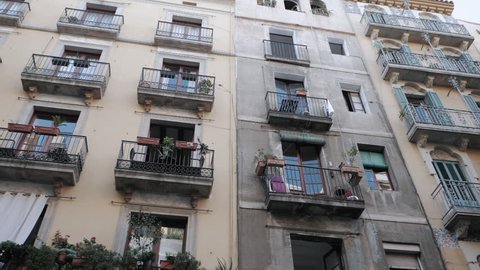 Apartment building streets in Barceloneta area. House with balconies in Barcelona's Gothic Quarter. Facades of old houses in the narrow streets of Barcelona. Traveling concept. Slow motion.