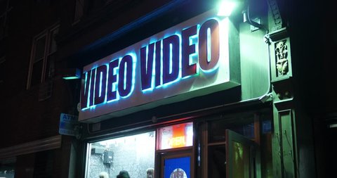 A nighttime establishing shot of a video store in Manhattan. Day/Night matching available.  	