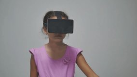 Close-up shot of a girl teen in headphones getting experience in using vr-headset. Augmented indoor reality device creating virtual space for smartphone applications