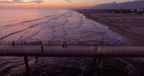 Aerial, people walking on the pier in Forte dei Marmi on sunset