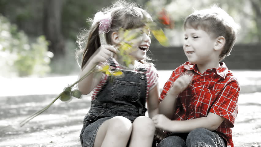 Two child speaking and playing with flower 