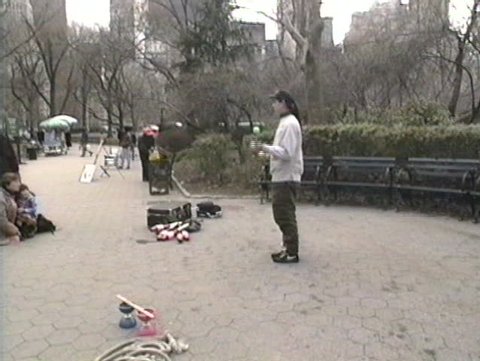 NEW YORK CITY, USA - CIRCA 1997: New Yorkers enjoy Sunday looking at a juggler in Central Park USA Circa 1997