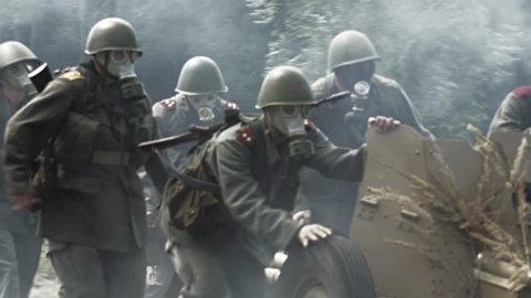 Soldiers moving a anti tank gun forward on a battlefield – heavy smoke