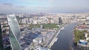4K aerial high quality aerial video of Moscow City area, International business center, Moscow River with bridge, skyscrapers and boats along the river in Russia on cloudy quiet autumn September day